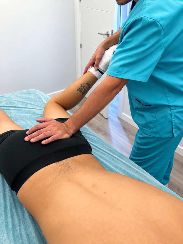 Osteópata colegiado aplicando técnica manual en zona lumbar en Alcobendas
